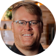 Headshot of carter moore - man with blonde hair and glasses